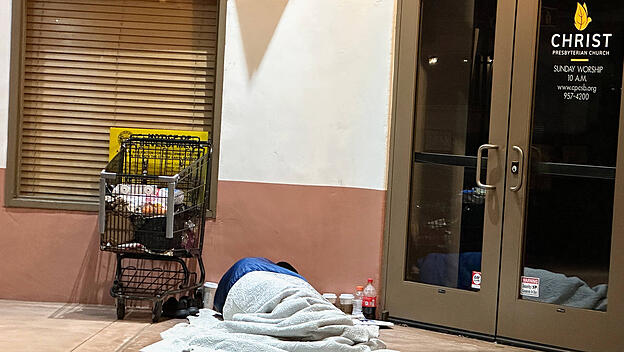 Obdachloser vor einer christlichen Gemeinde