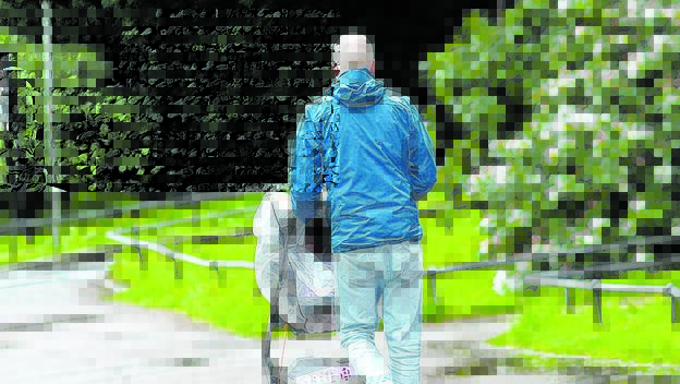 Vater fährt Kind im Kinderwagen