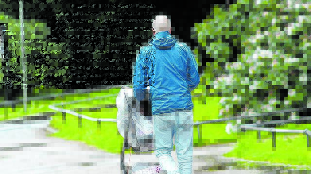 Vater fährt Kind im Kinderwagen