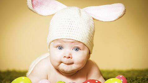 Baby mit Hasenmütze und Ostereiern