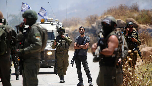 Israelische Soldaten und Siedler blockieren Anfang Juni östlich von Idhna bei Hebron im Westjordanland Zufahrtswege