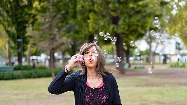 Reife Transfrau beim Blasen von Seifenblasen in einem Park *** mature trans woman at blow from Soap bubbles in a Park Co
