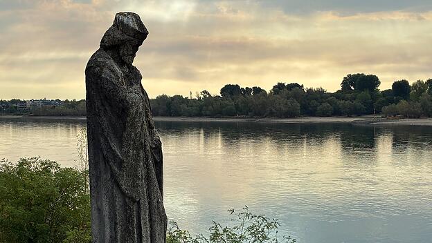 Der heilige Nepomuk am Rheinufer bei Köln als Mahnmal: dramatische Klimafolgen sind auch Aufforderung zu Selbstkritik und Umkehr.