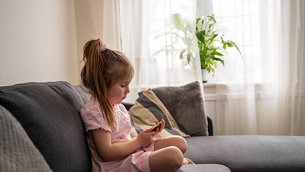 Girl using her smartphone, watching video online at home Corby, England, United Kingdom R_ATMT250318-1684658-01 ,model r