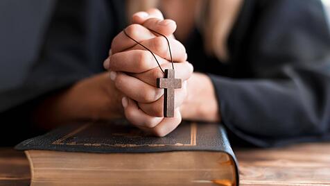 Betende Person mit Kreuz und heiligem Buch *** Betende Person with Cross and holy Book Copyright: imageBROKER/Oleksandrx