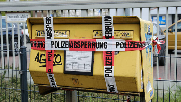 Ein außer Betrieb gesetzter Briefkasten wird mit Polizeiband umwickelt, um zu verhindern, dass Post eingeworfen wird